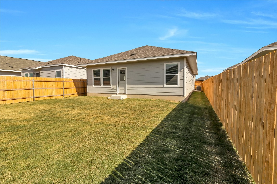 160 The Bad Way Jarrell, TX 76537 - Photo 33 of 33 Rear view of house featuring a fenced backyard and roof with shingles