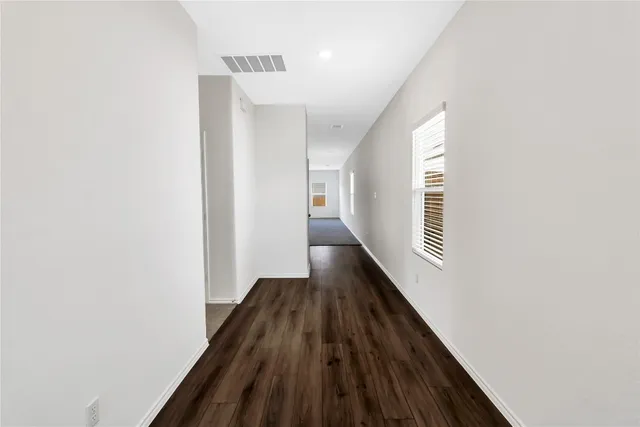 a view of a hallway with wooden floor