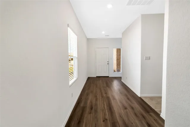 a view of a hallway with wooden floor