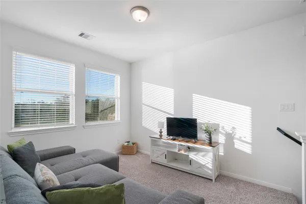 a living room with furniture a flat screen tv and a window