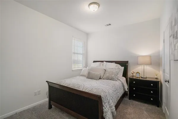a bedroom with a bed and a lamp