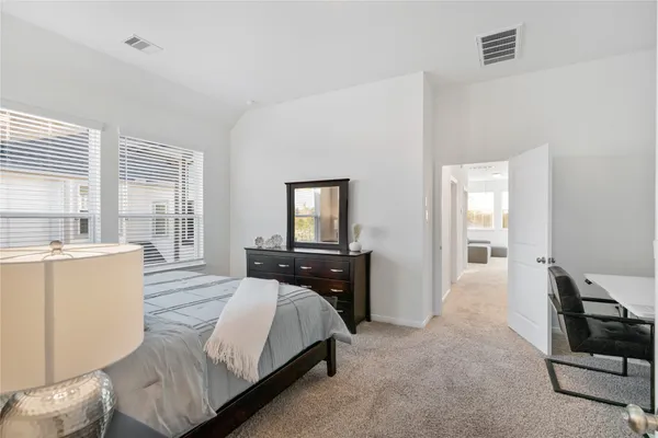a bedroom with a bed and large windows