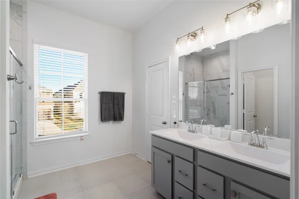 a bathroom with double vanity and a mirror