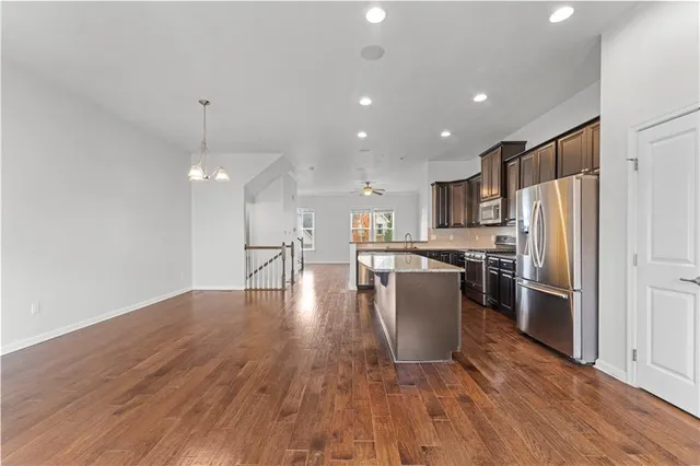 a kitchen with a refrigerator and a wooden floor