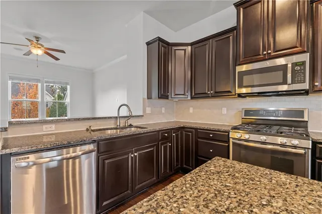 a kitchen with stainless steel appliances granite countertop a sink stove and microwave