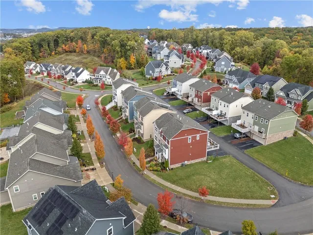 an aerial view of residential houses with outdoor space and parking