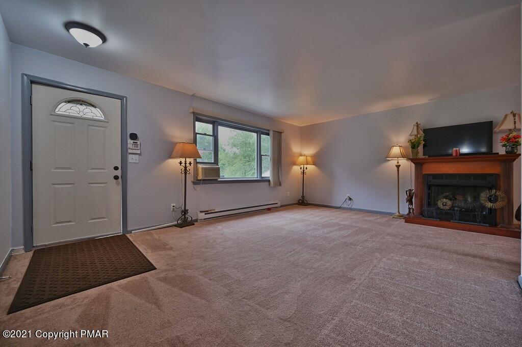 273 Devils Hole Road Cresco, PA 18326 - Photo 13 of 59 an empty room with windows fire place and fireplace