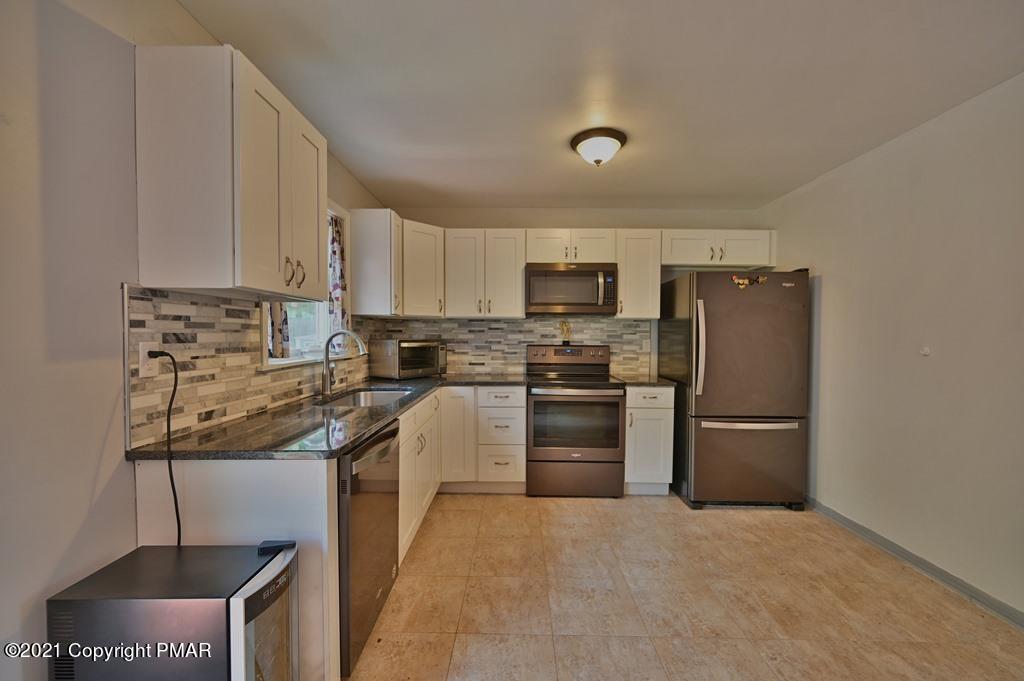 273 Devils Hole Road Cresco, PA 18326 - Photo 19 of 59 a kitchen with stainless steel appliances granite countertop a refrigerator stove and microwave