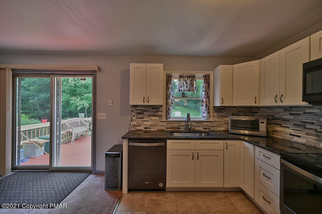 273 Devils Hole Road Cresco, PA 18326 - Photo 20 of 59 a kitchen with stainless steel appliances granite countertop a stove a sink and a microwave