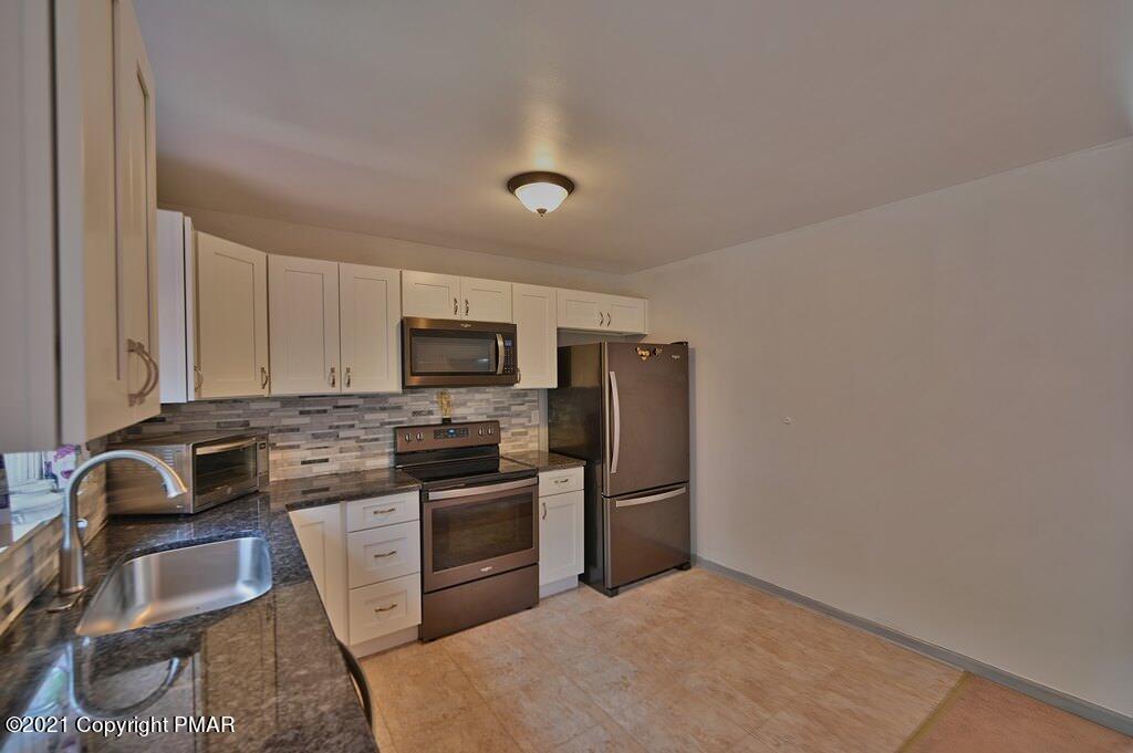 273 Devils Hole Road Cresco, PA 18326 - Photo 22 of 59 a kitchen with stainless steel appliances granite countertop a stove a sink dishwasher a refrigerator and a microwave