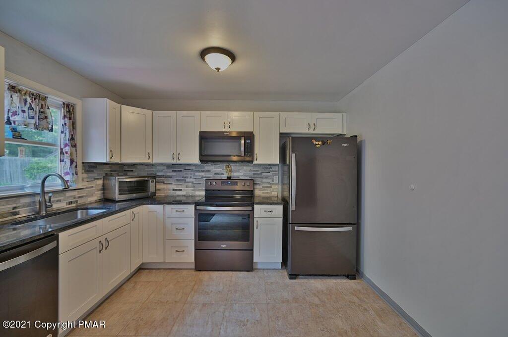 273 Devils Hole Road Cresco, PA 18326 - Photo 23 of 59 a kitchen with a refrigerator sink and cabinets