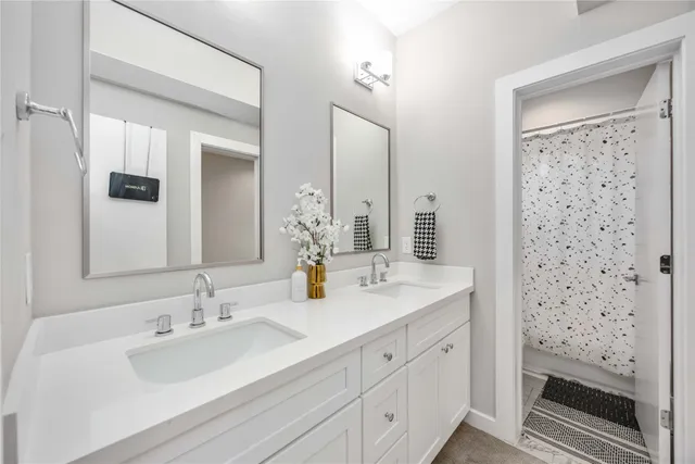 a bathroom with double vanity sink and mirror