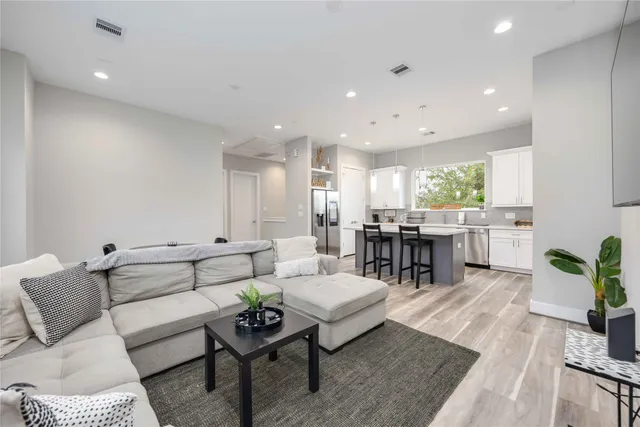 a living room with lots of furniture and kitchen view