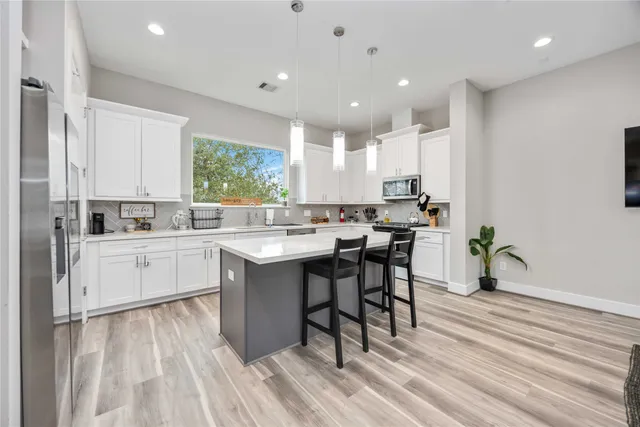 a kitchen with a sink white cabinets and white appliances