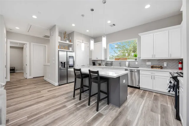 a kitchen with a sink cabinets and wooden floor