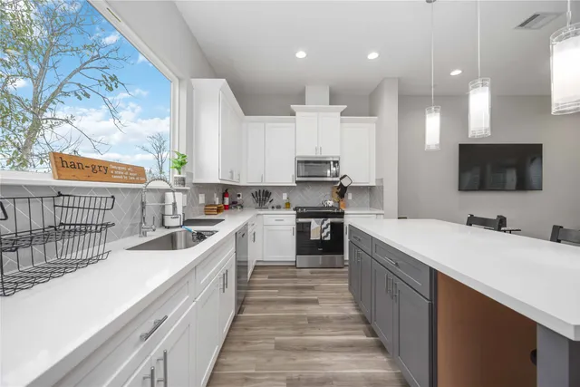a large kitchen with kitchen island a sink stainless steel appliances and cabinets