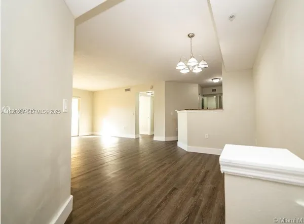 a view of a room with wooden floor and windows