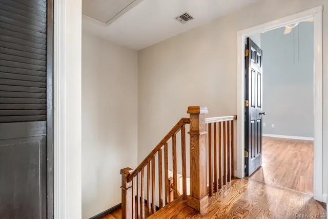 a view of a hallway with wooden floor and stairs