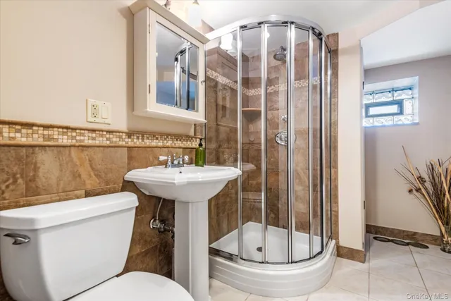 a bathroom with a sink a toilet a mirror and shower