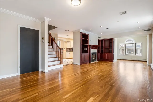 a view of an empty room with a kitchen and a window