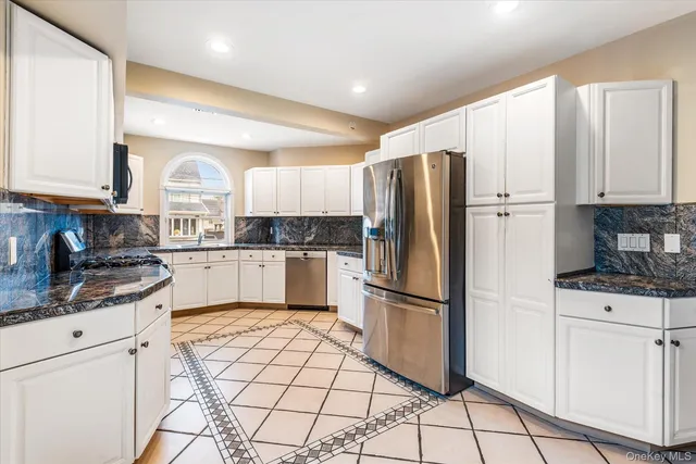 a kitchen with granite countertop a refrigerator stove top oven and sink