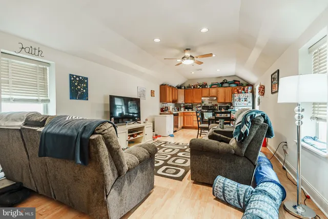 a living room with furniture a ceiling fan and a window