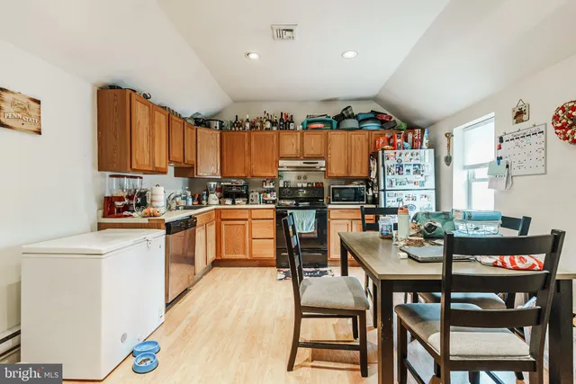 a kitchen with a table chairs stove and cabinets