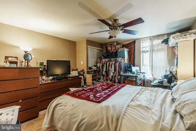 a bedroom with a bed a tv and wooden floor