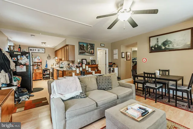 a living room with furniture kitchen view and a window