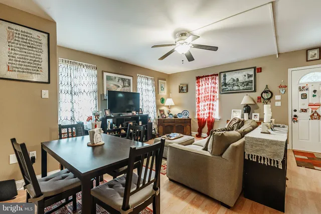 a living room with furniture a flat screen tv and a dining table