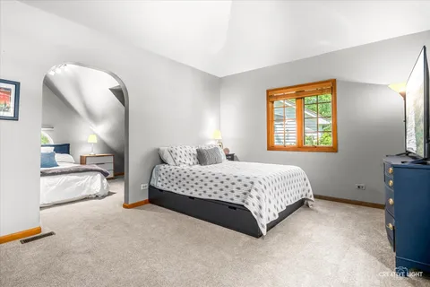 a spacious bedroom with a bed and a lamp