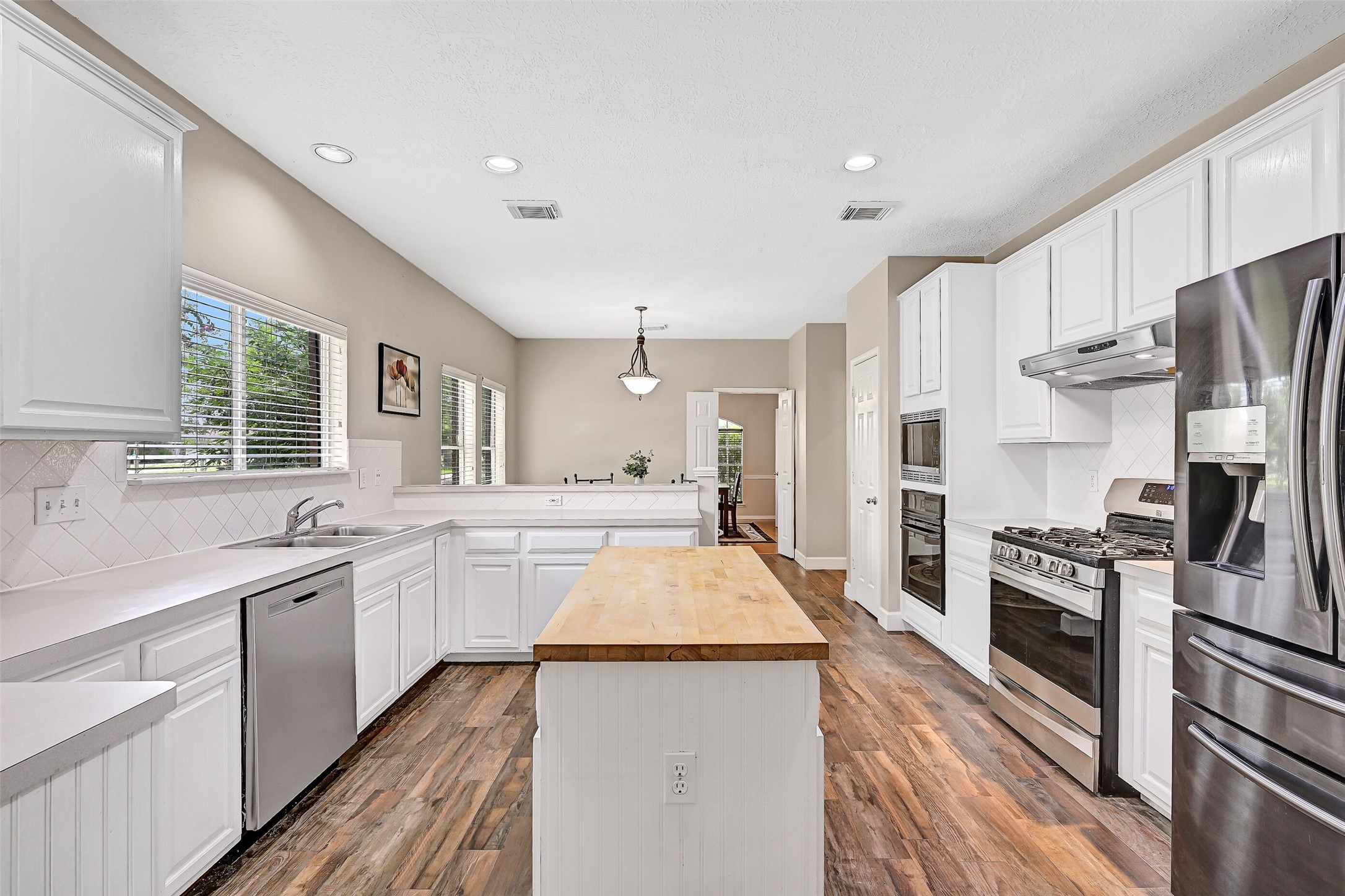 1606 Falcon Ridge Boulevard Friendswood, TX 77546 - Photo 13 of 24 a large kitchen with stainless steel appliances lots of counter space and wooden floor