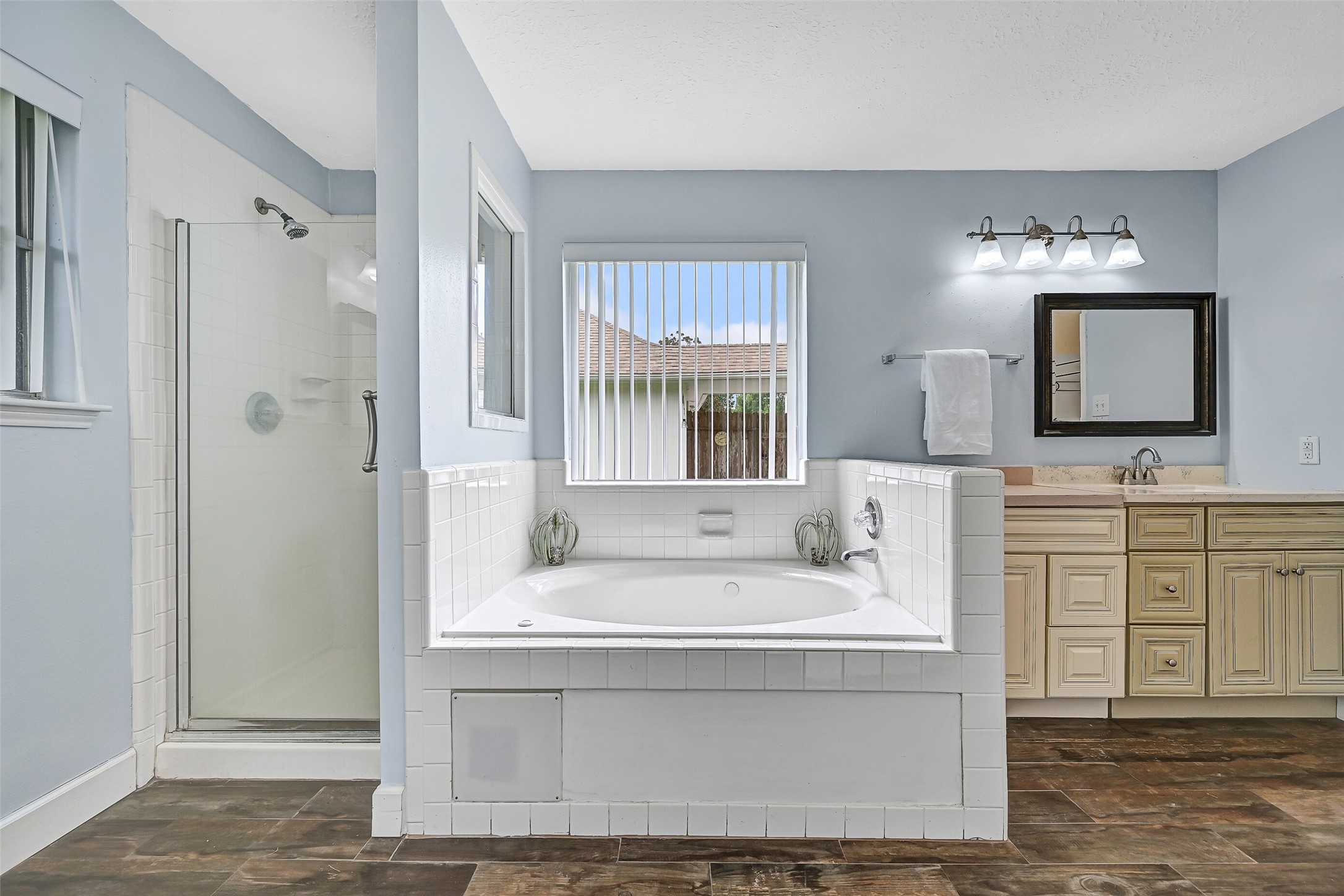 1606 Falcon Ridge Boulevard Friendswood, TX 77546 - Photo 18 of 24 a bathroom with a tub a sink and a mirror