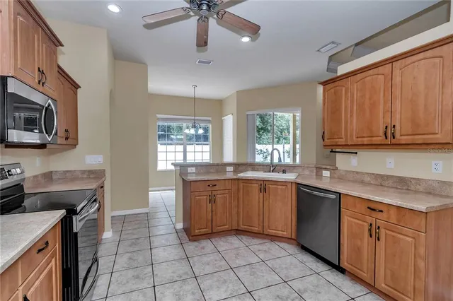 a kitchen with stainless steel appliances granite countertop stove top oven a sink dishwasher and a microwave oven on the blue kitchen countertops