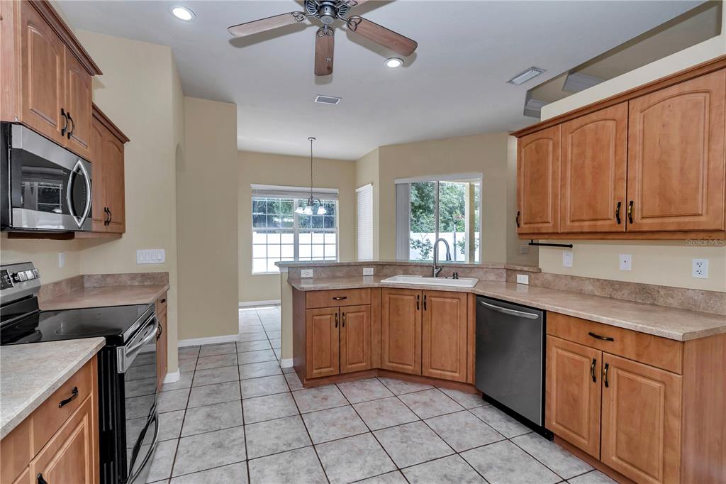 57 Chrysanthemum Drive Ormond Beach, FL 32174 - Photo 12 of 35 a kitchen with stainless steel appliances granite countertop stove top oven a sink dishwasher and a microwave oven on the blue kitchen countertops