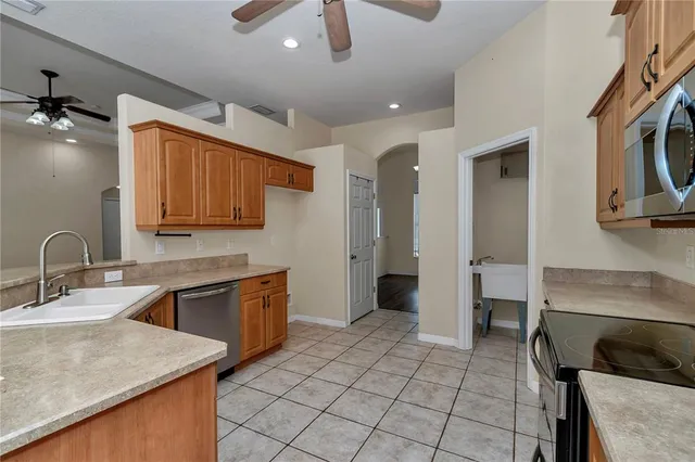 a kitchen with stainless steel appliances granite countertop a sink and a stove top oven with wooden floor