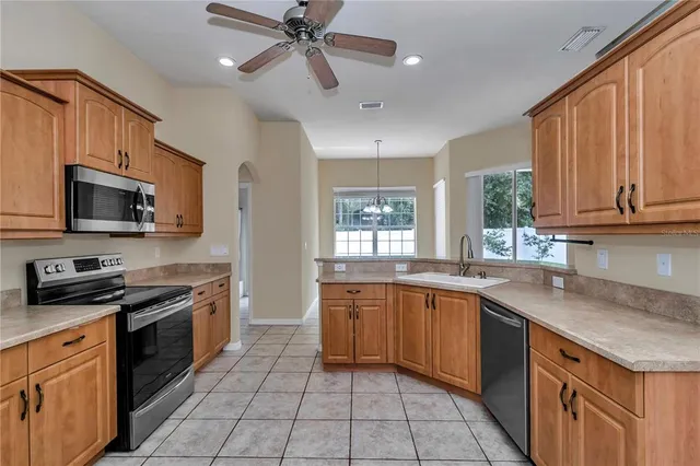 a kitchen with stainless steel appliances granite countertop a sink and dishwasher a stove top oven with wooden floor