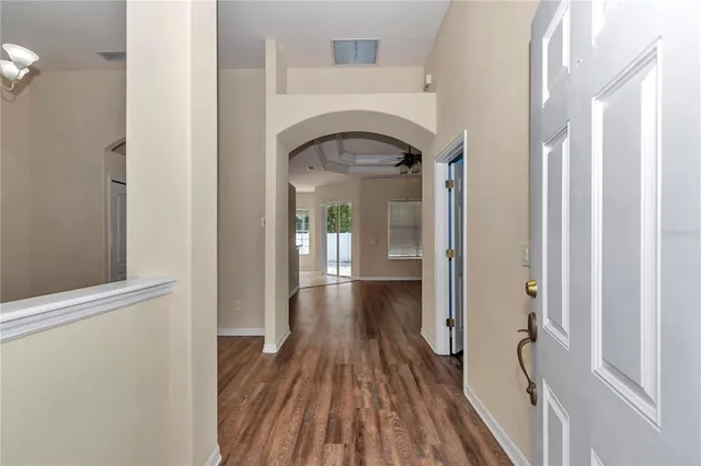 a view of a hallway with wooden floor and staircase