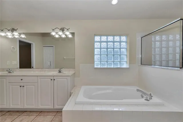 a spacious bathroom with a granite countertop sink a toilet a mirror and shower