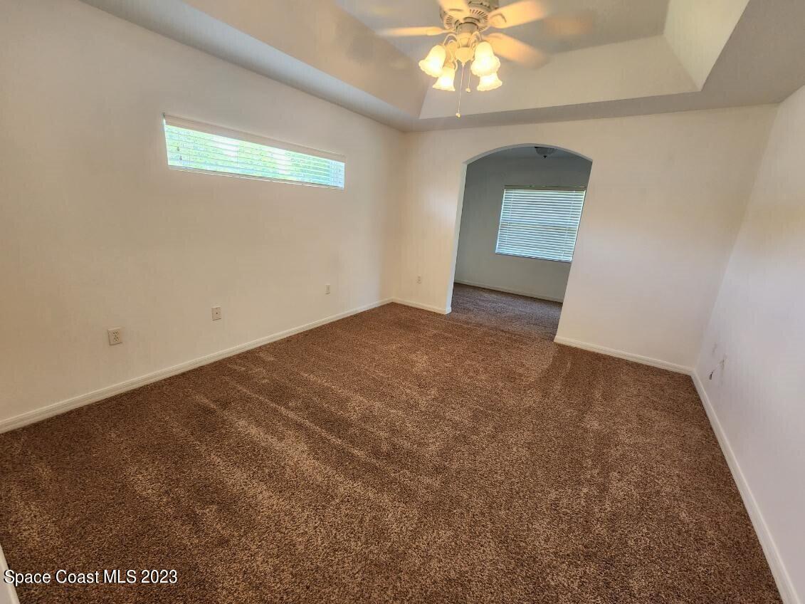 2004 Gloria Circle Palm Bay, FL 32905 - Photo 34 of 54 an empty room with a chandelier fan and windows