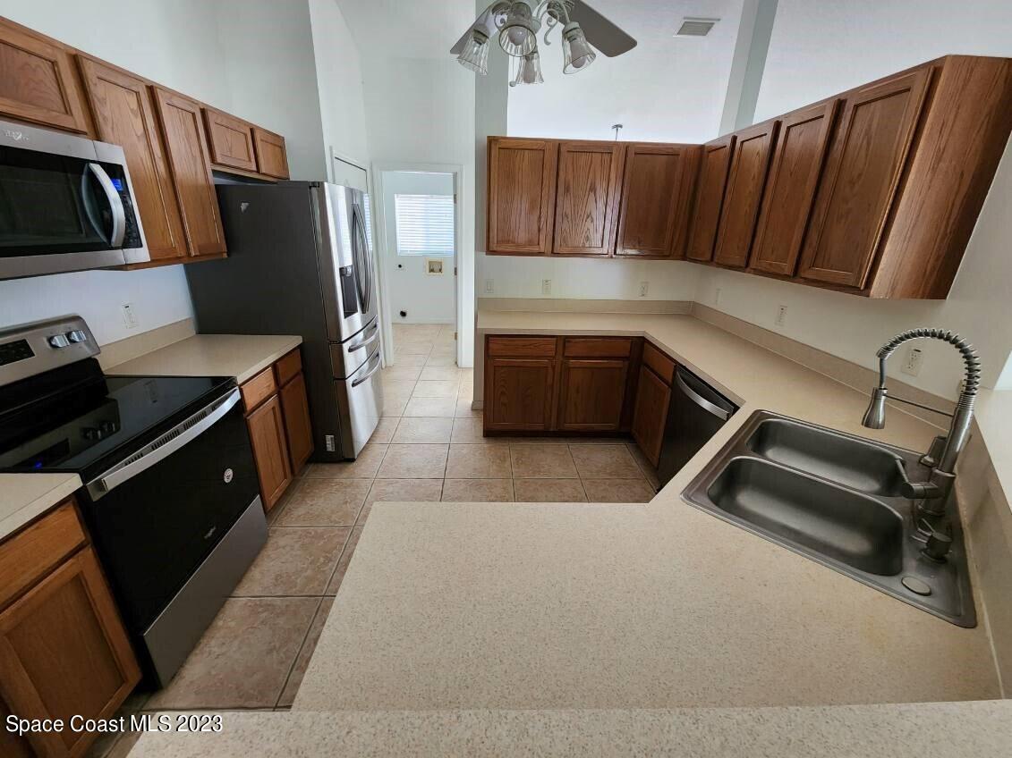 2004 Gloria Circle Palm Bay, FL 32905 - Photo 6 of 54 a kitchen with stainless steel appliances a stove a refrigerator and wooden cabinets