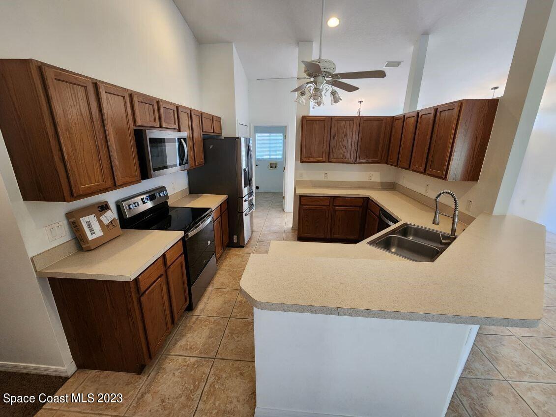 2004 Gloria Circle Palm Bay, FL 32905 - Photo 7 of 54 a kitchen with stainless steel appliances a sink a stove a refrigerator a washer dryer and white cabinets