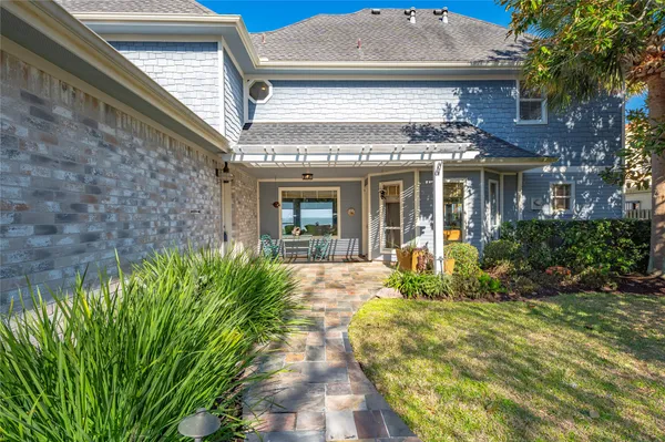 a view of a white house with a large window and flower plants