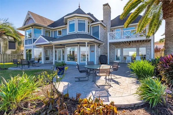 a view of a patio with couches table and chairs potted plants and large tree