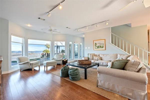 a living room with furniture wooden floor and floor to ceiling window