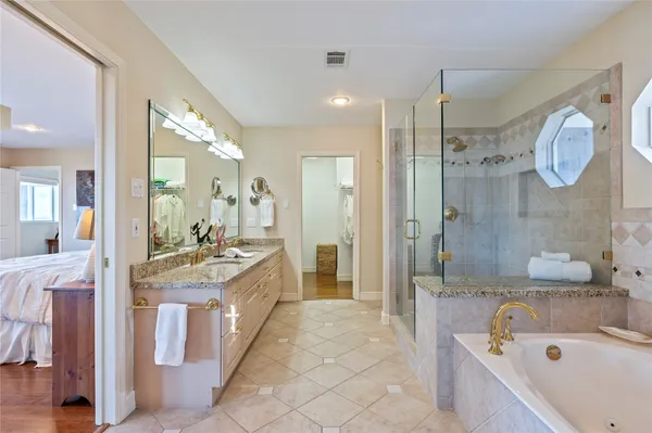 a large bathroom with a granite countertop sink a large mirror a shower and bathtub