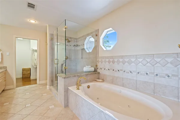 a bathroom with a bathtub a sink and a large mirror