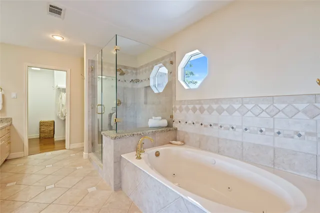 a bathroom with a bathtub a sink and a large mirror
