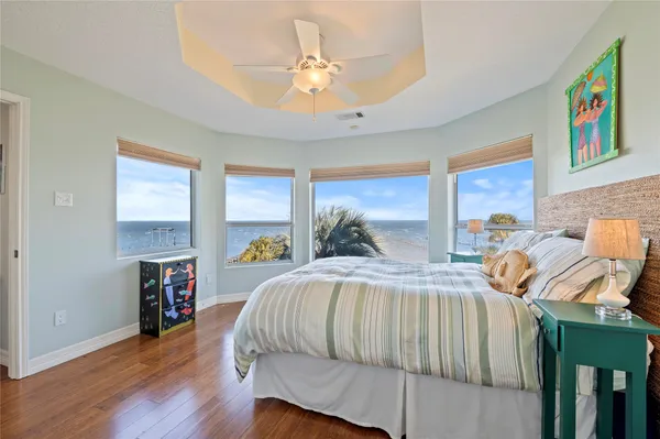 a bedroom with a bed a table and a large window