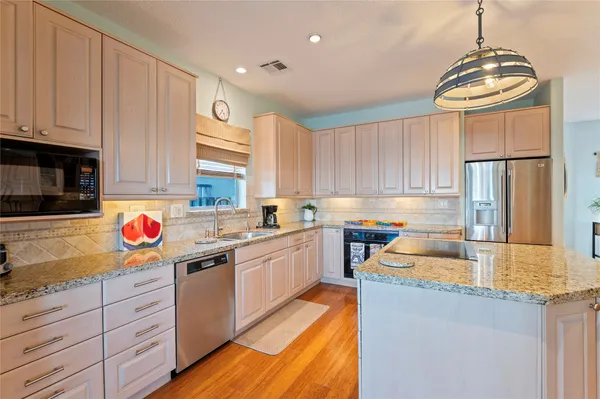 a kitchen with stainless steel appliances granite countertop a sink stove and refrigerator
